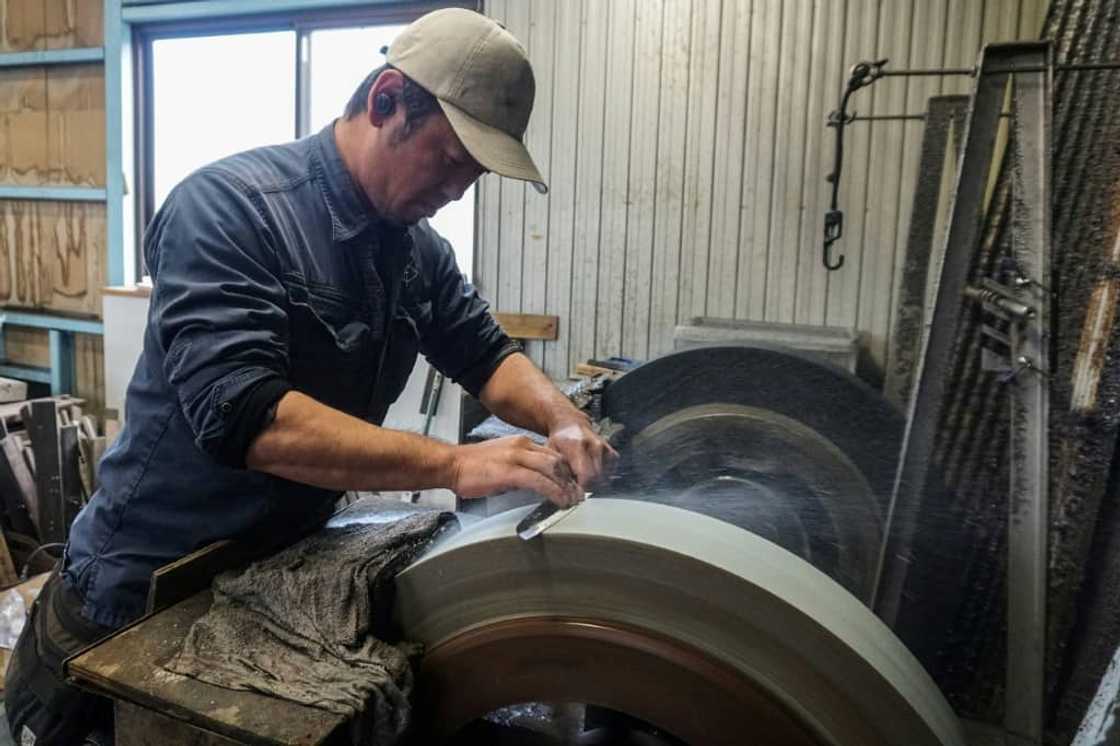 Yoshihiro Yauji sharpens a freshly forged 'santoku', a multipurpose knife, at the Takefu Knife Village in Fukui prefecture