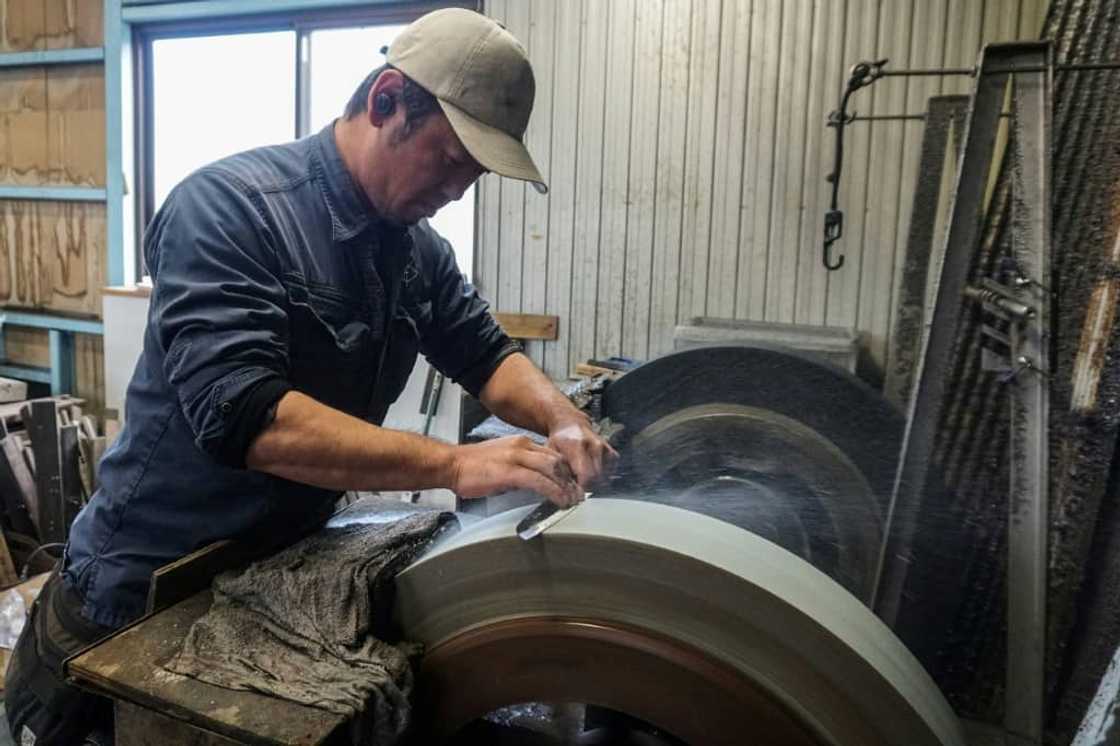 Yoshihiro Yauji sharpens a freshly forged 'santoku', a multipurpose knife, at the Takefu Knife Village in Fukui prefecture Yoshihiro Yauji sharpens a freshly forged 'santoku', a multipurpose knife, at the Takefu Knife Village in Fukui prefecture