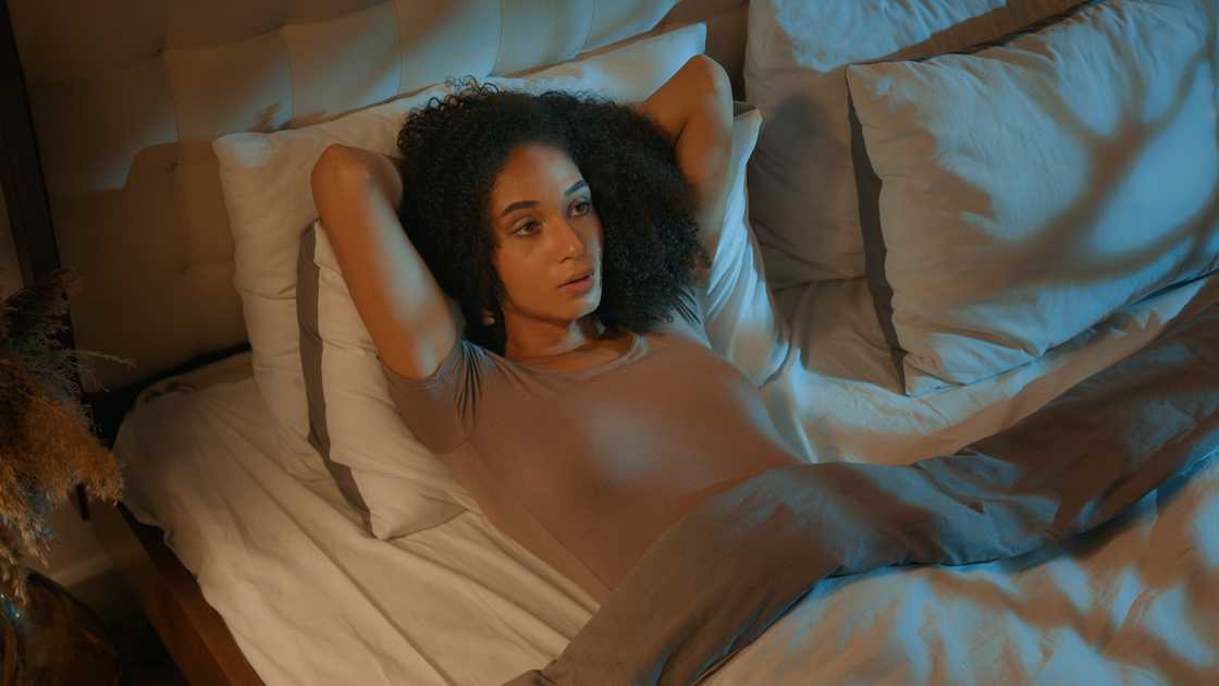 A thoughtful woman lying on the bed A thoughtful woman lying on the bed