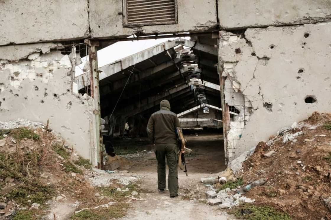 A Ukrainian soldier enters a destroyed building at an industrial chicken farm, near which the Russian forces were dug in A Ukrainian soldier enters a destroyed building at an industrial chicken farm, near which the Russian forces were dug in