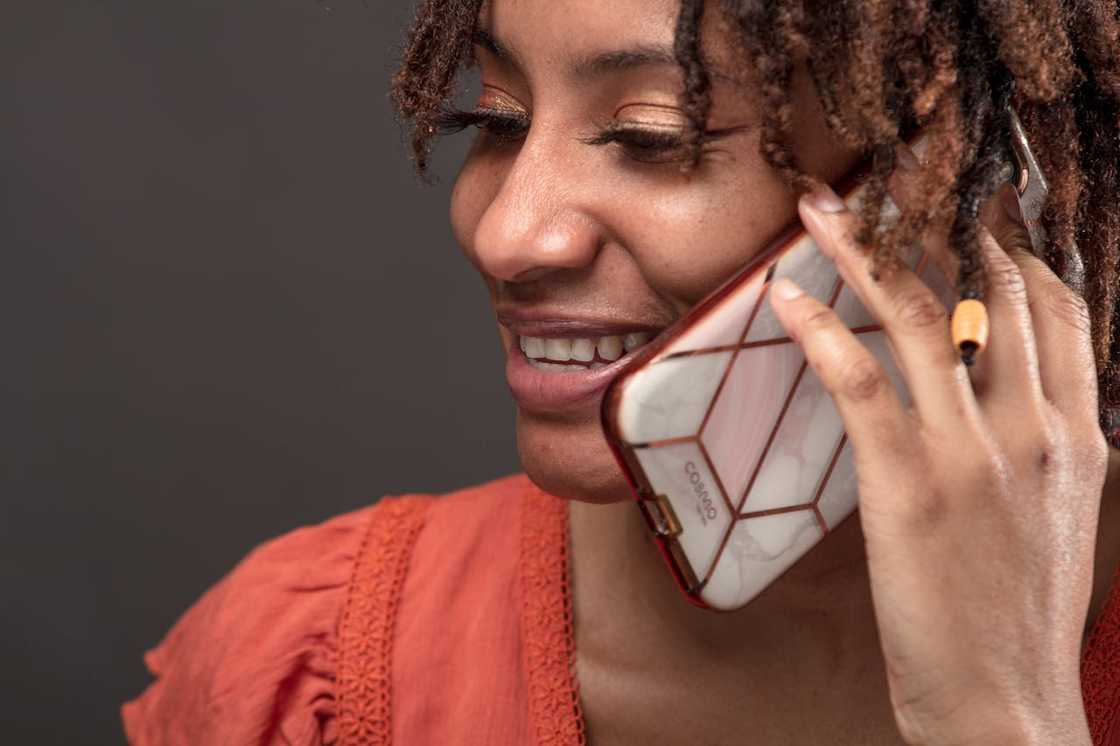 A woman smiles while talking on her phone.