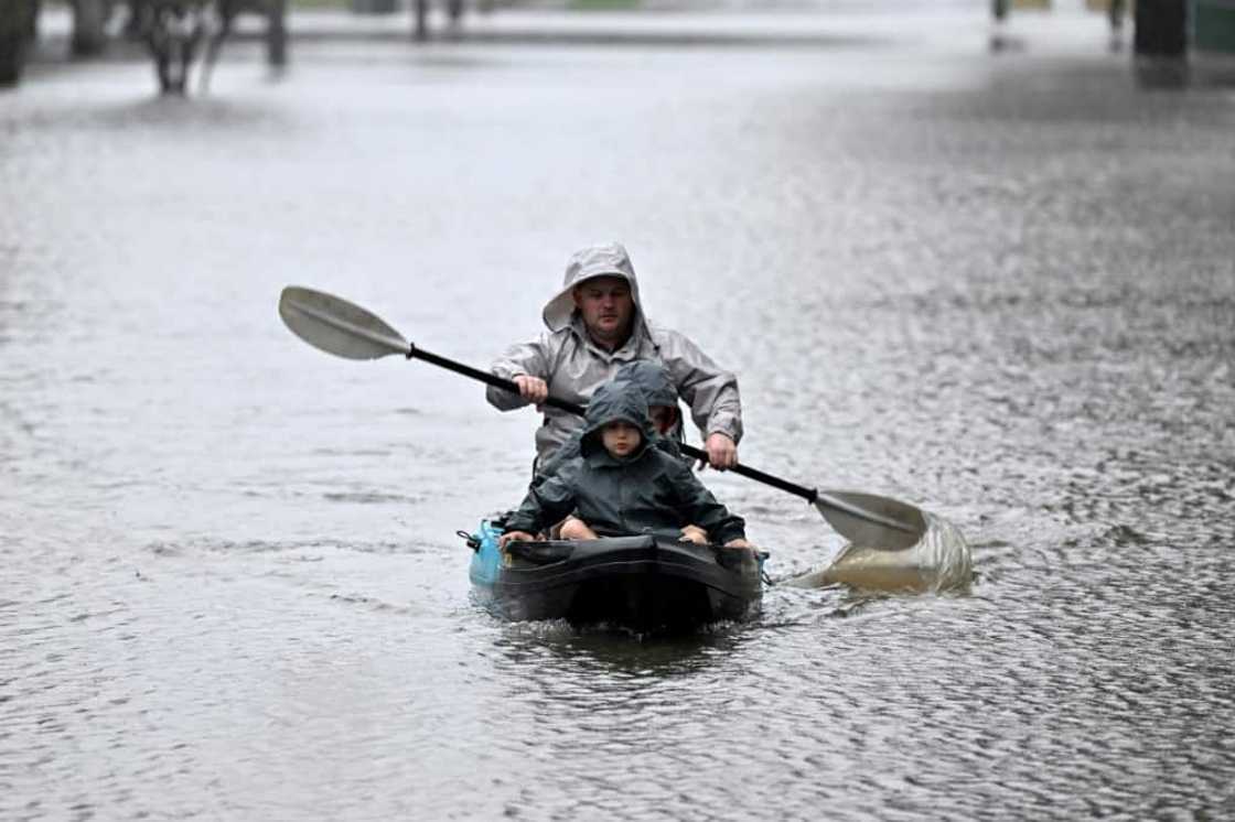 Rain-swollen rivers spilled mud-brown waters across swathes of Sydney, swamping homes and roads while forcing thousands to flee