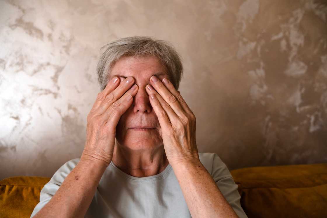 Woman holds her face
