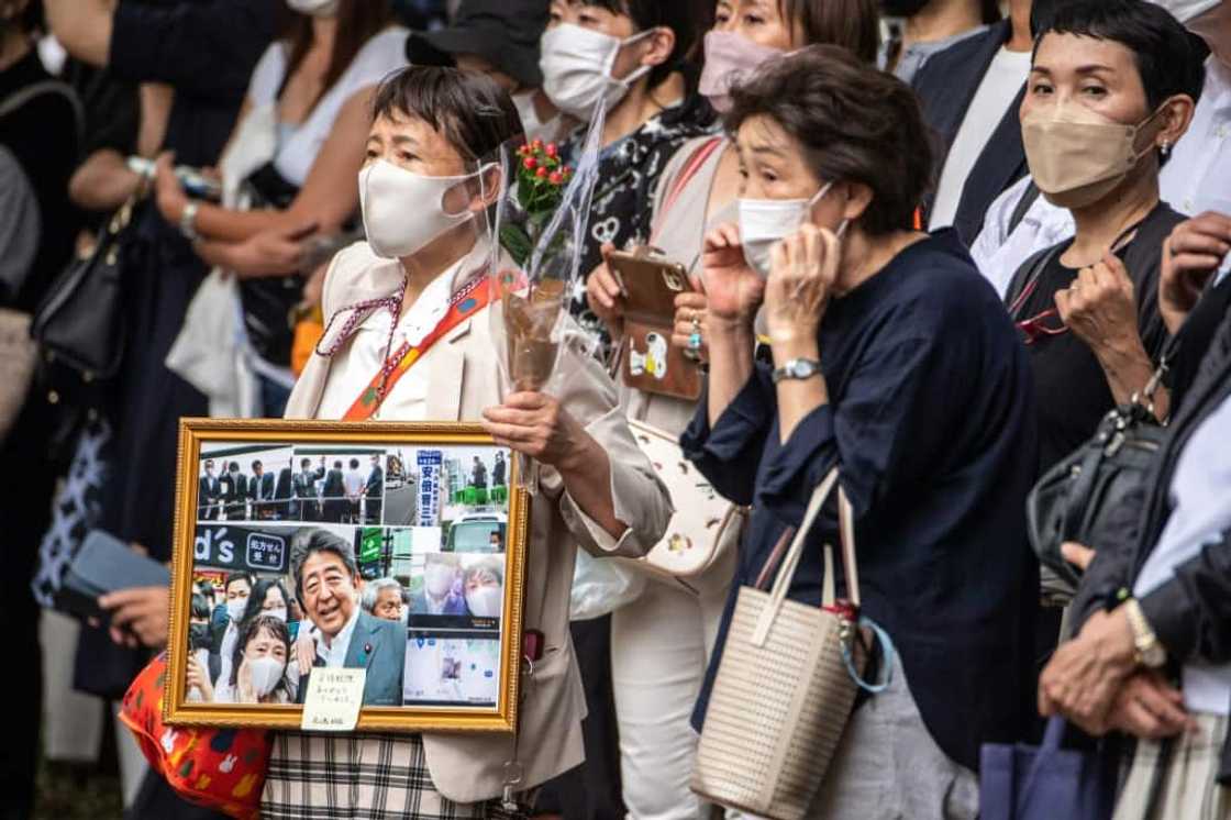 Mourners gather in July as a hearse carrying late former Japanese prime minister Shinzo Abe leaves Zojoji Temple in Tokyo