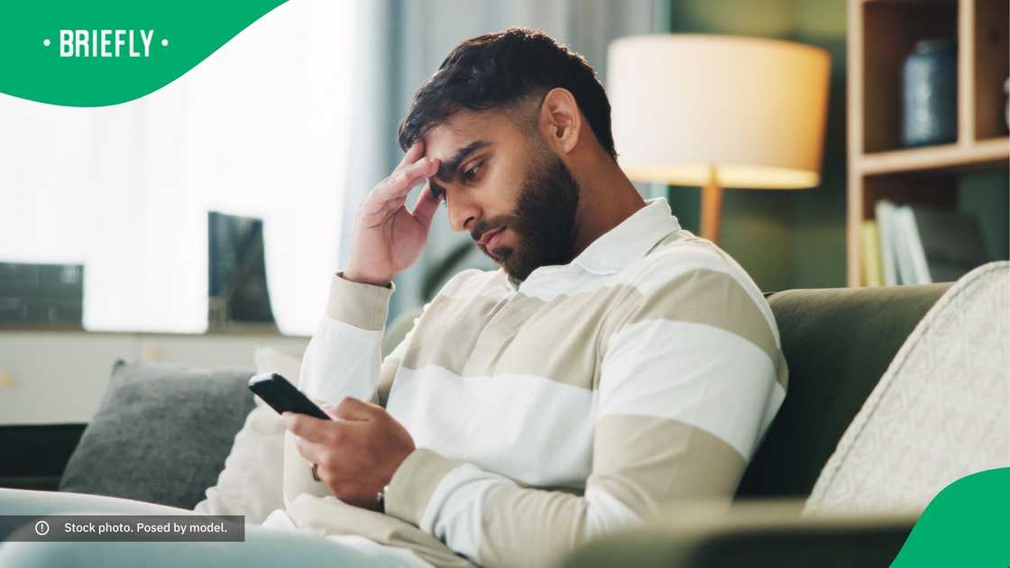 A confused man looking at his phone. A confused man looking at his phone.