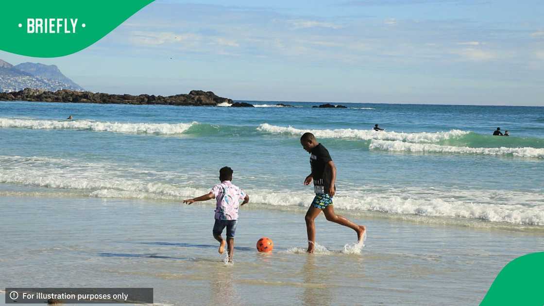 A man and his child play football on the Blouberg Beach on August 17, 2025 in Cape Town, South Africa A man and his child play football on the Blouberg Beach on August 17, 2025 in Cape Town, South Africa