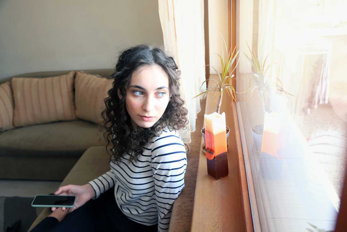 A woman sitting on a coach. A woman sitting on a coach.