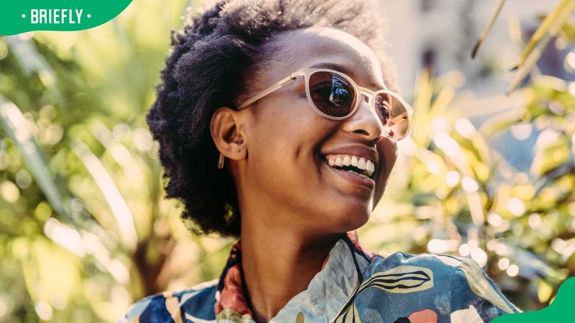 Portrait of a happy young woman wearing sunglasses in the garden