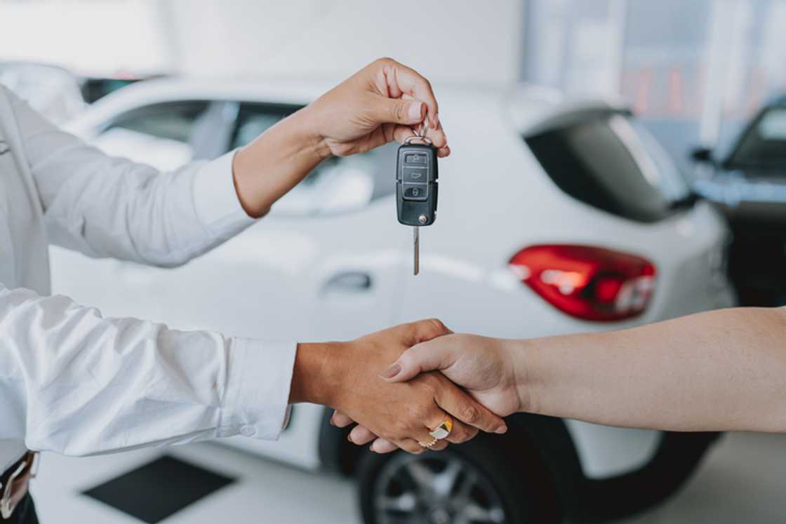 A person handing over a car key