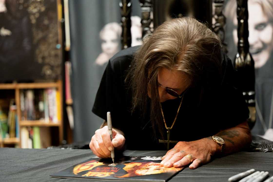 Musician Ozzy Osbourne signing copies of his album