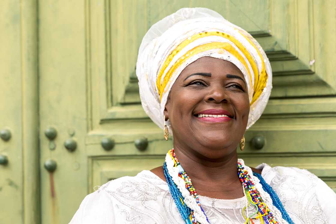 An African woman smiling with traditional attire. An African woman smiling with traditional attire.