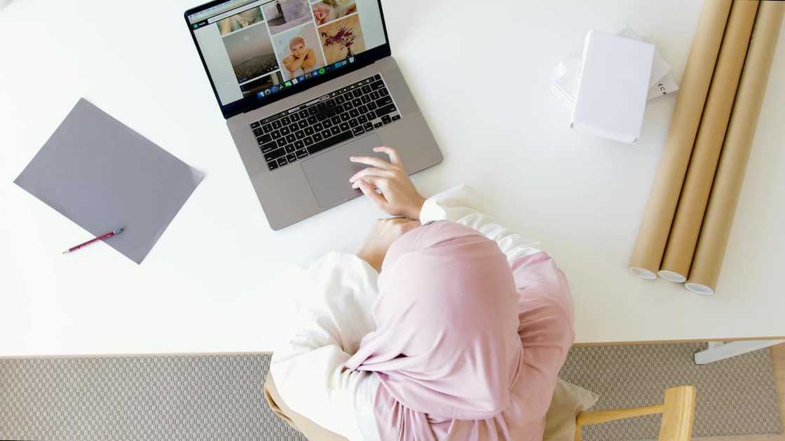 A woman in a pink Hijab using a laptop A woman in a pink Hijab using a laptop