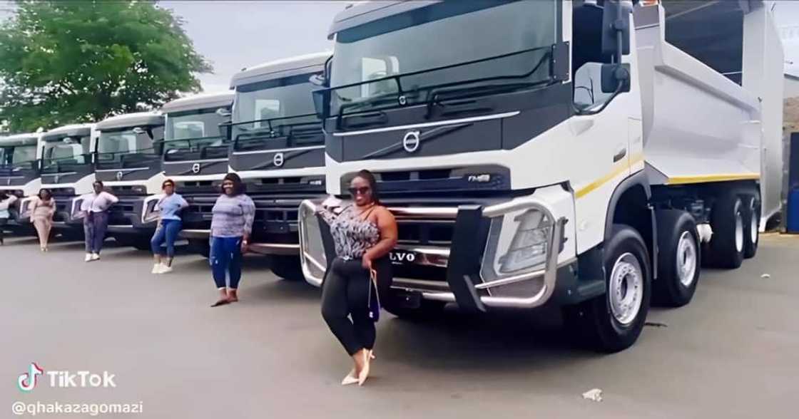 Female truckers posed in front of their vehicles Female truckers posed in front of their vehicles