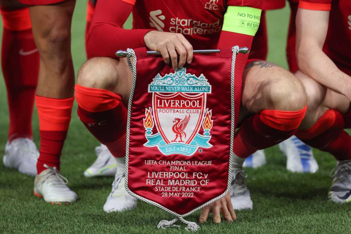 Jordan Henderson holds a pennant commemorating the match. Jordan Henderson holds a pennant commemorating the match.