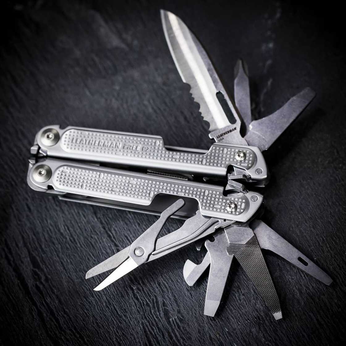 A silver multi-tool against a black background A silver multi-tool against a black background