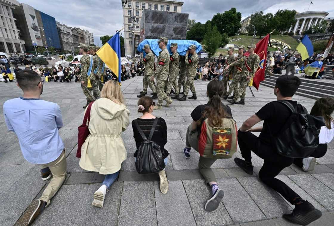 Mourners approached the body in turn, kneeling or bowing and placing a hand on the coffin where many flowers were laid