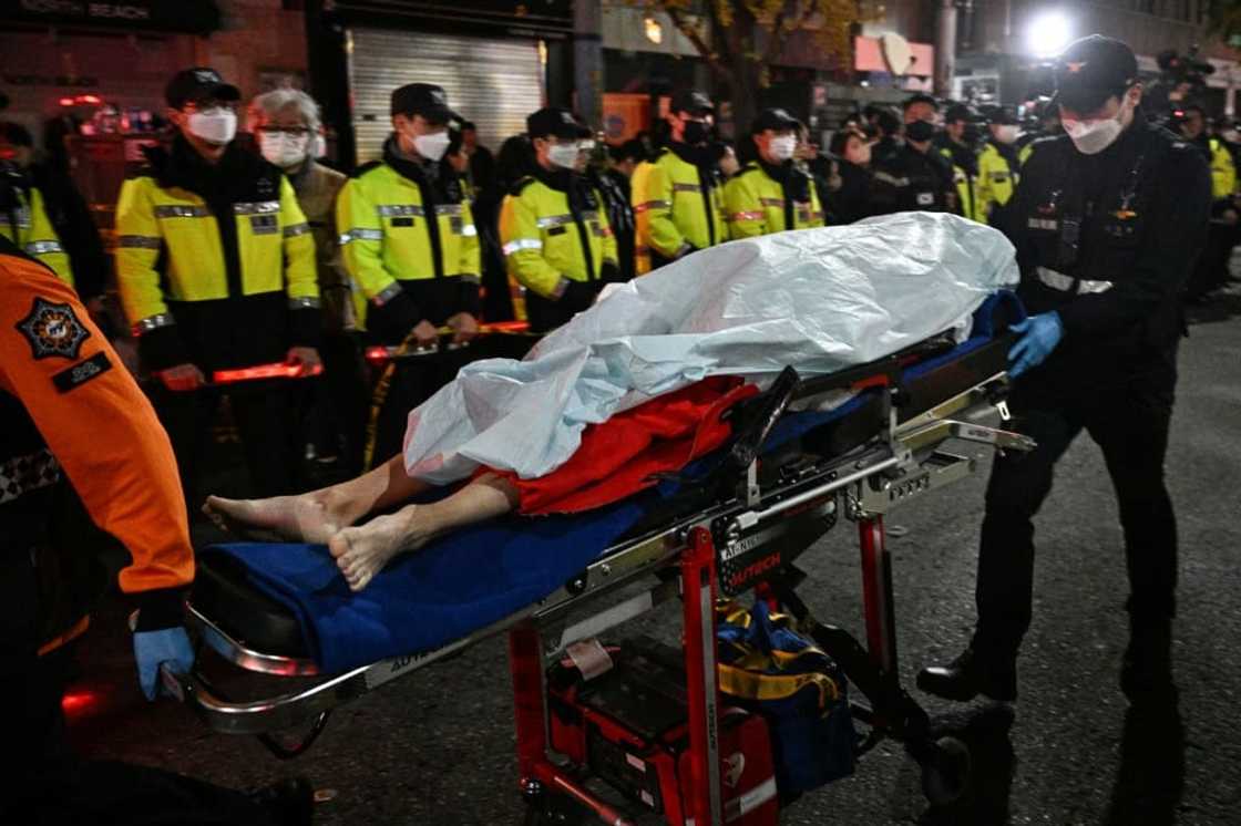 The body of a victim of a Halloween stampede is carried on a stretcher in Seoul on October 30, 2022 The body of a victim of a Halloween stampede is carried on a stretcher in Seoul on October 30, 2022