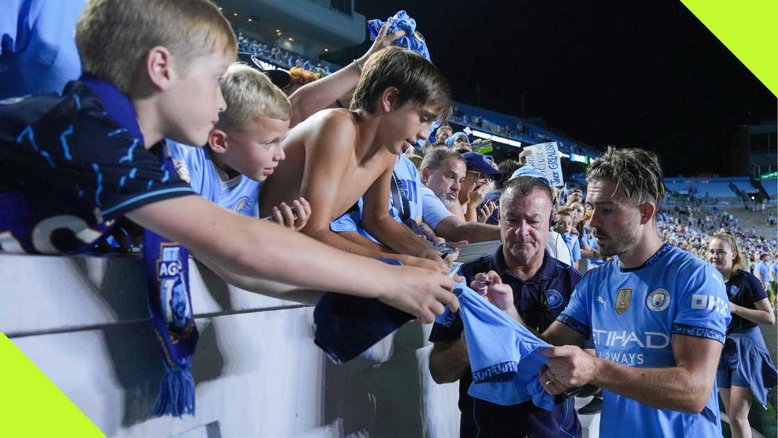 Jack Grealish signs autographs for fans.