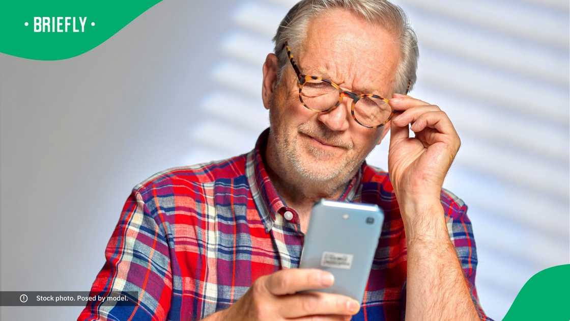 A confused man looking at his phone.