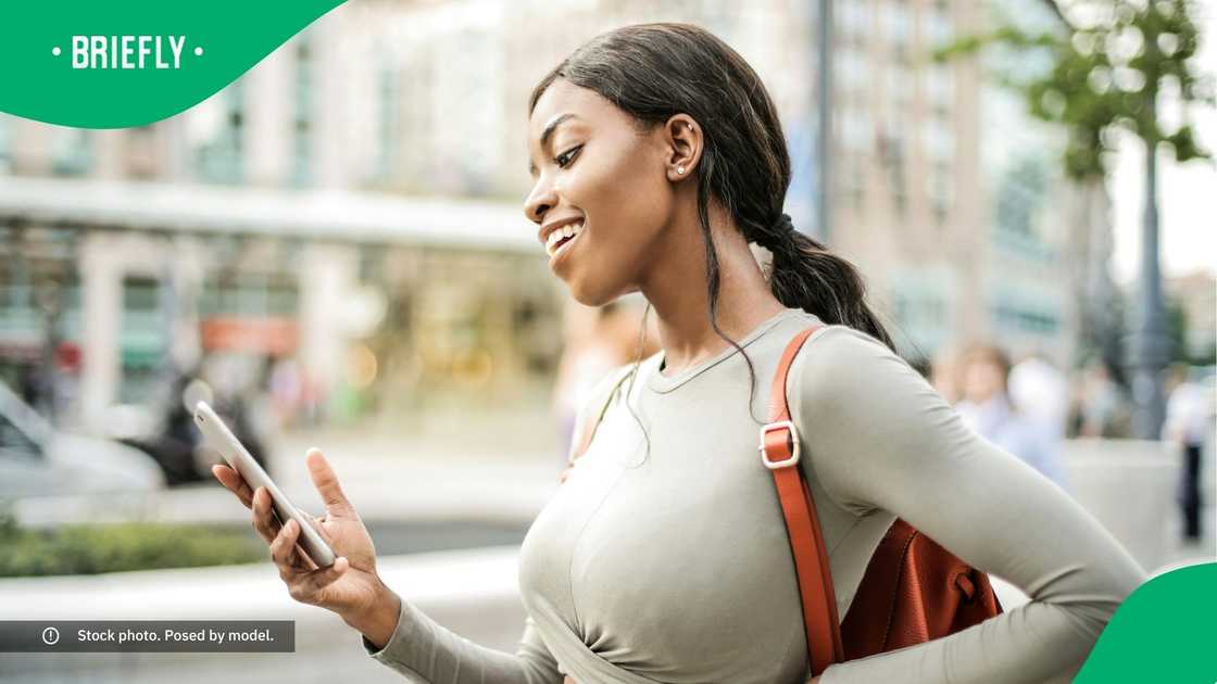 A woman smiling at her phone. A woman smiling at her phone.