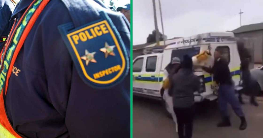 Image of police officers handcuffing a man to a police van