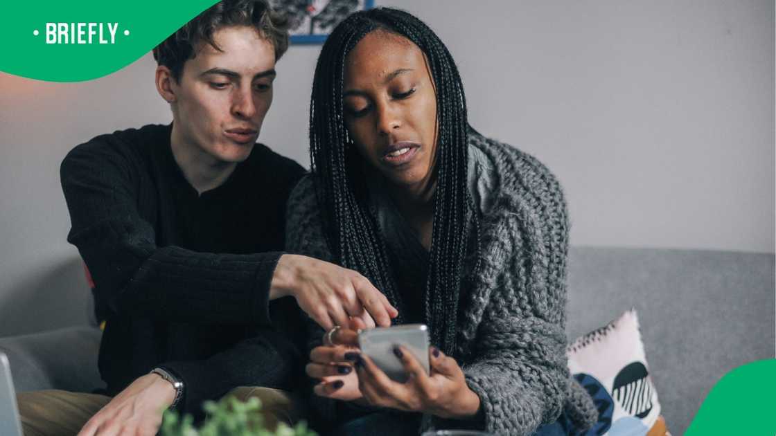 Young couple looking at something on a phone Young couple looking at something on a phone