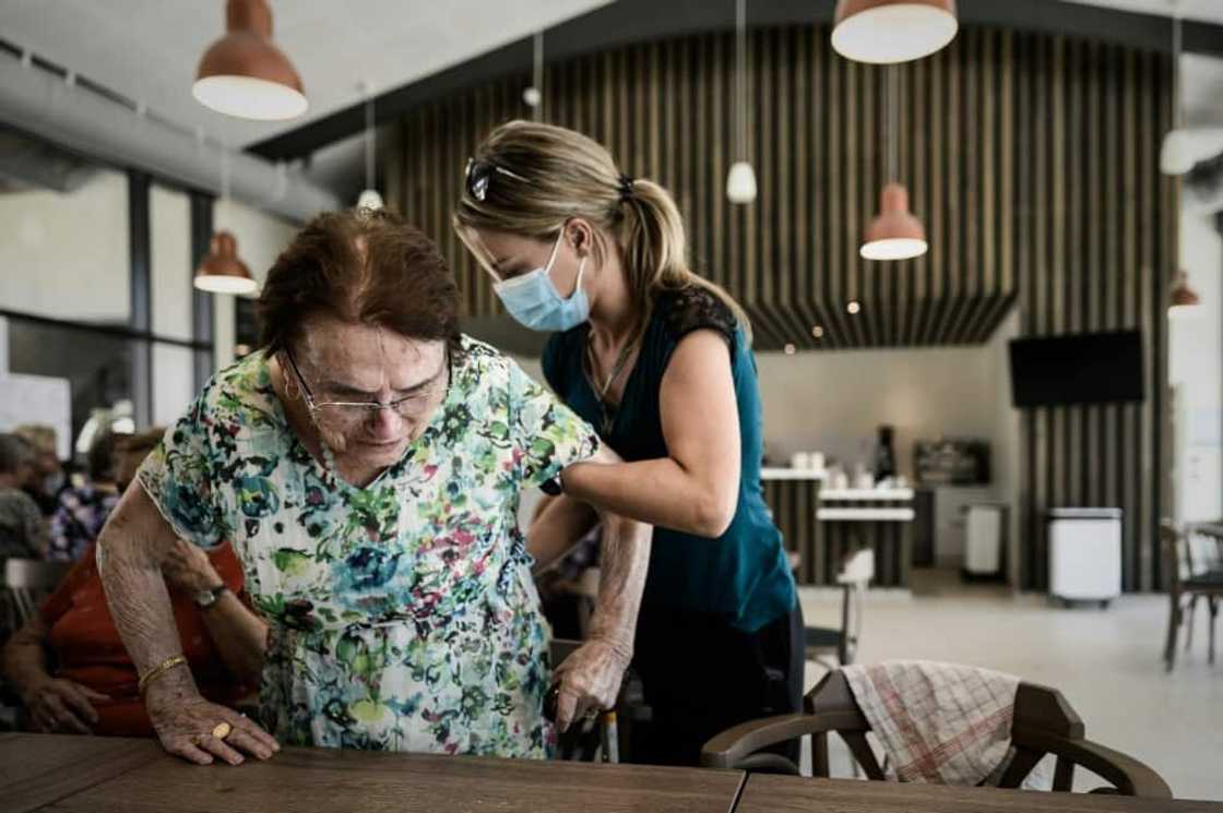 A volunteer attends to Alzheimer's patients at a center in Dax, southwestern France