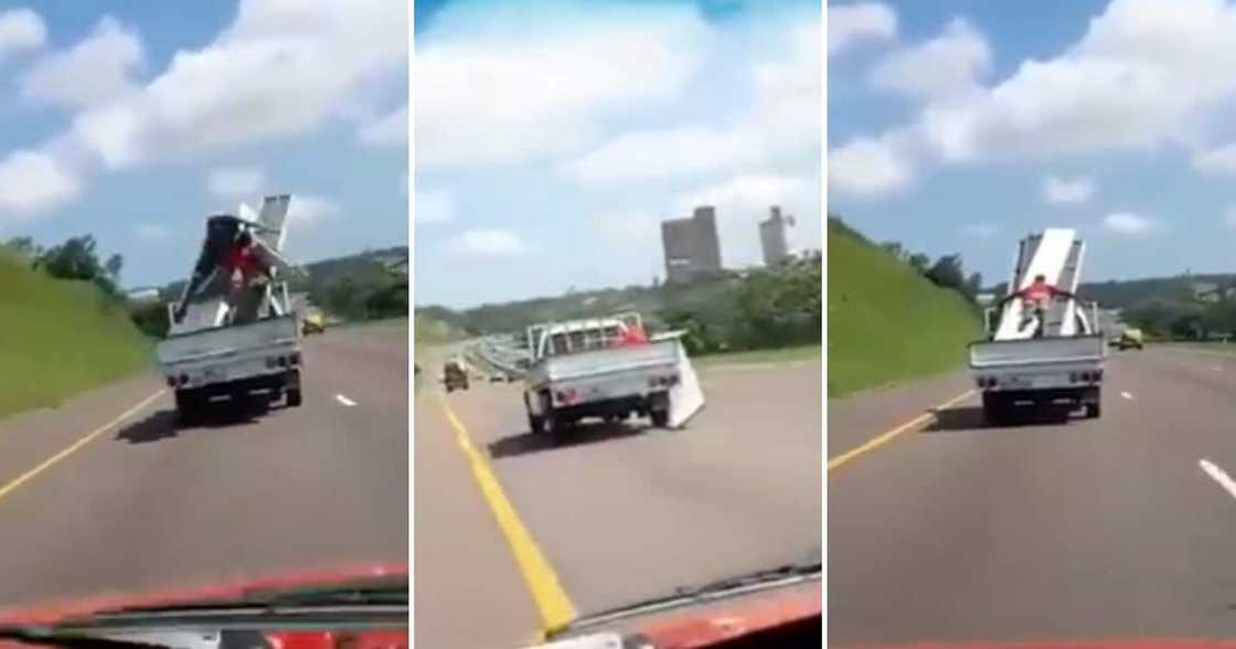 Man anchoring metal sheets on the back of a bakkie Man anchoring metal sheets on the back of a bakkie