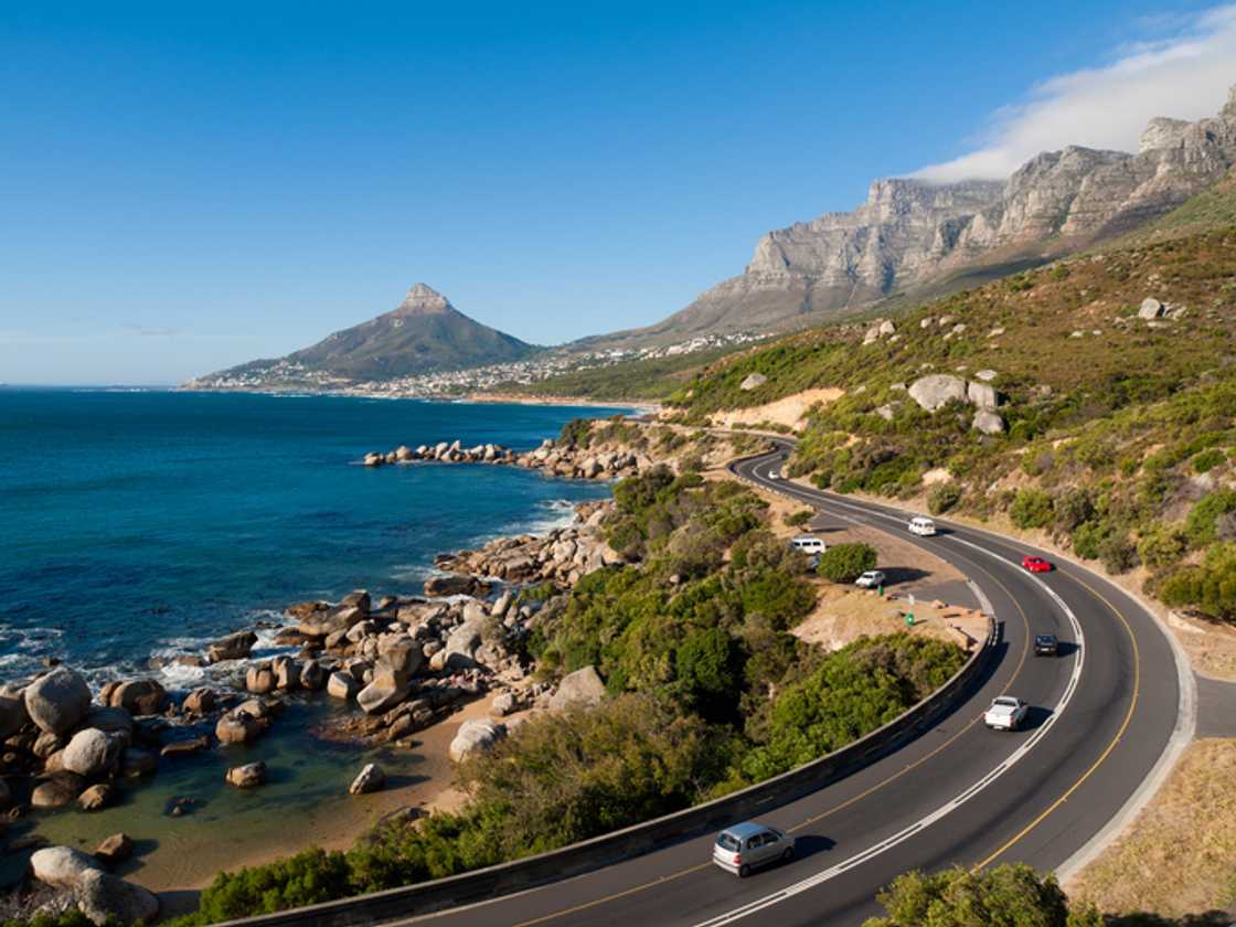 A group of cars were driving up a road in Cape Town, South Africa. A group of cars were driving up a road in Cape Town, South Africa.