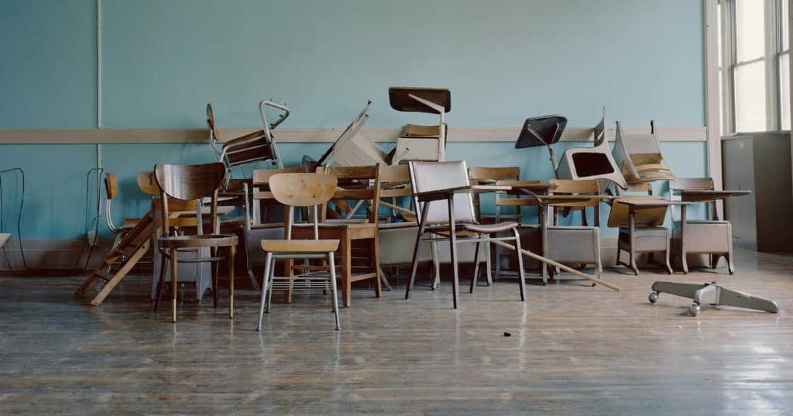 Picture of chairs stacked on each in an empty classroom