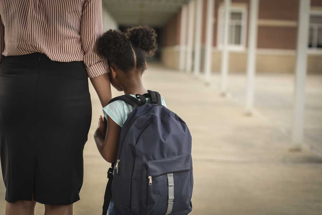 A girl holds her mom's hand