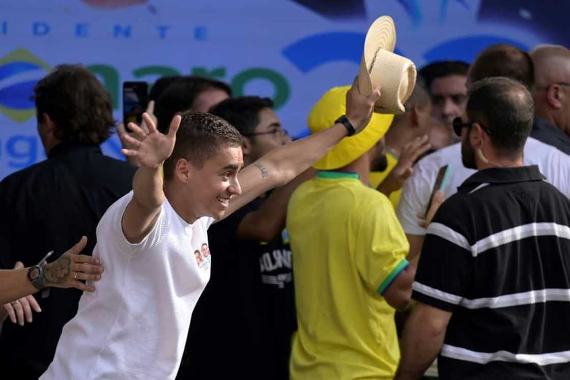 Nikolas Ferreira greets the crowd at a campaign appearance in Minas Gerais state on October 18, 2022