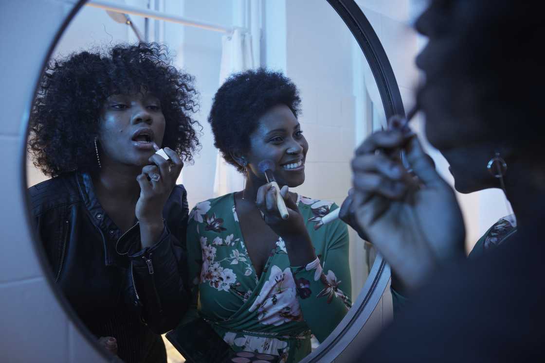 Two women fixing makeup in a restroom. Two women fixing makeup in a restroom.