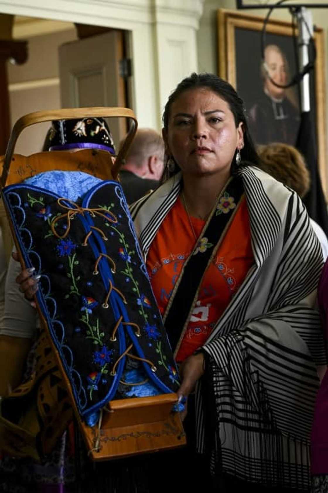 An Indigenous woman carries a traditional baby cradle in memory of Indigenous children, as she arrives to meet Pope Francis in Iqaluit, Nunavut, Canada, on July 29, 2022 An Indigenous woman carries a traditional baby cradle in memory of Indigenous children, as she arrives to meet Pope Francis in Iqaluit, Nunavut, Canada, on July 29, 2022