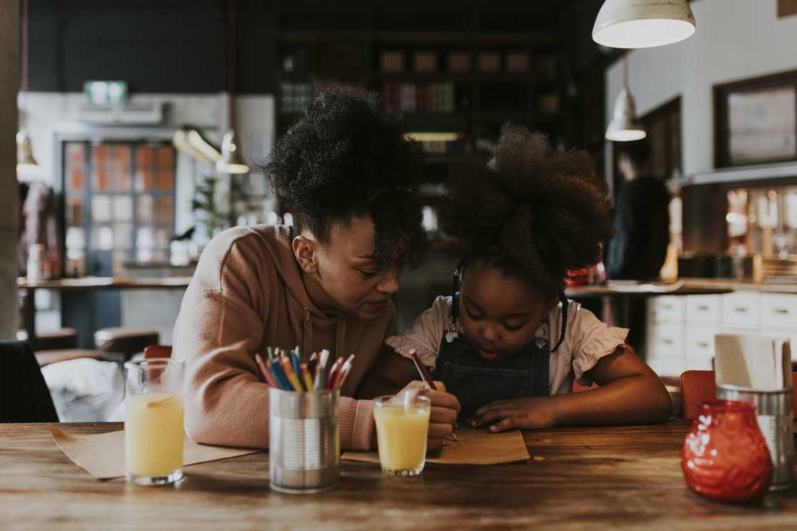 A mother helping her young daughter with homework. A mother helping her young daughter with homework.