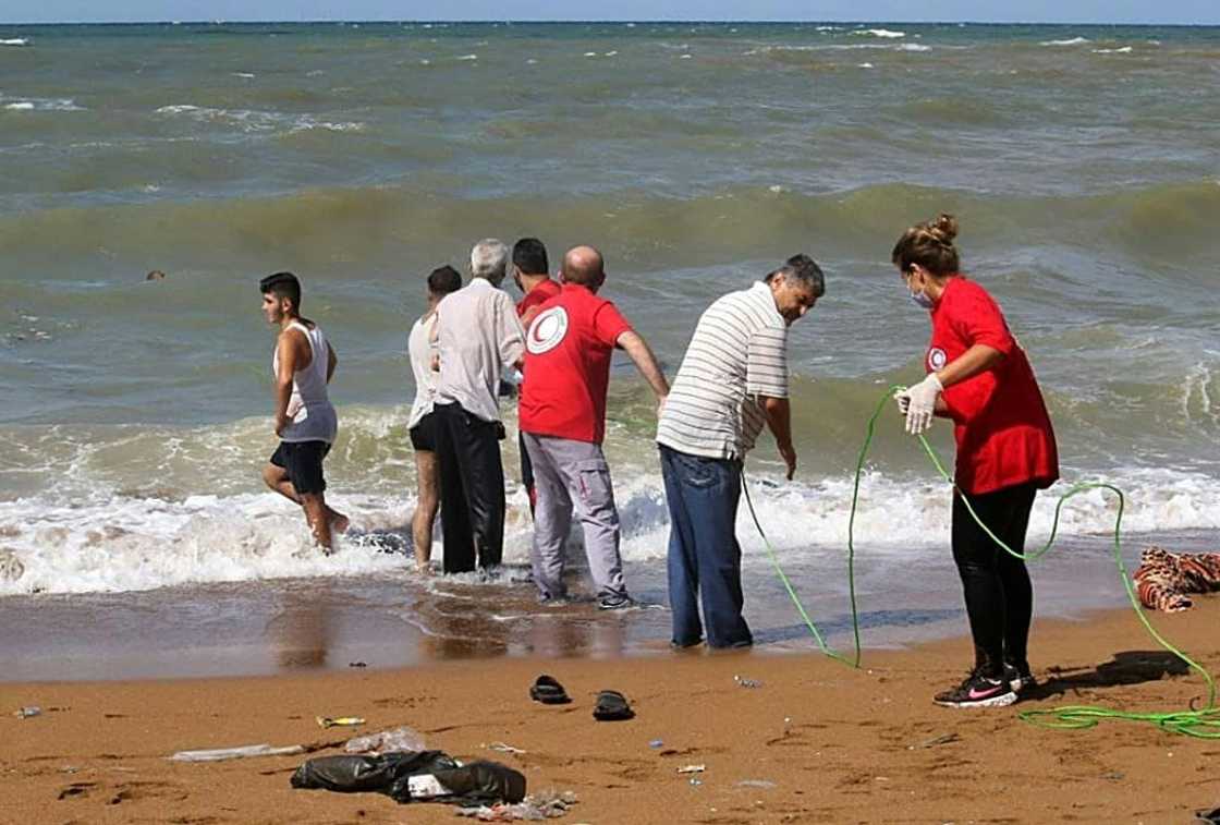 Rescuers from the Syrian Red Crescent recover the body of a migrant who drowned in a shipwreck off the coast after leaving Lebanon on Thursday