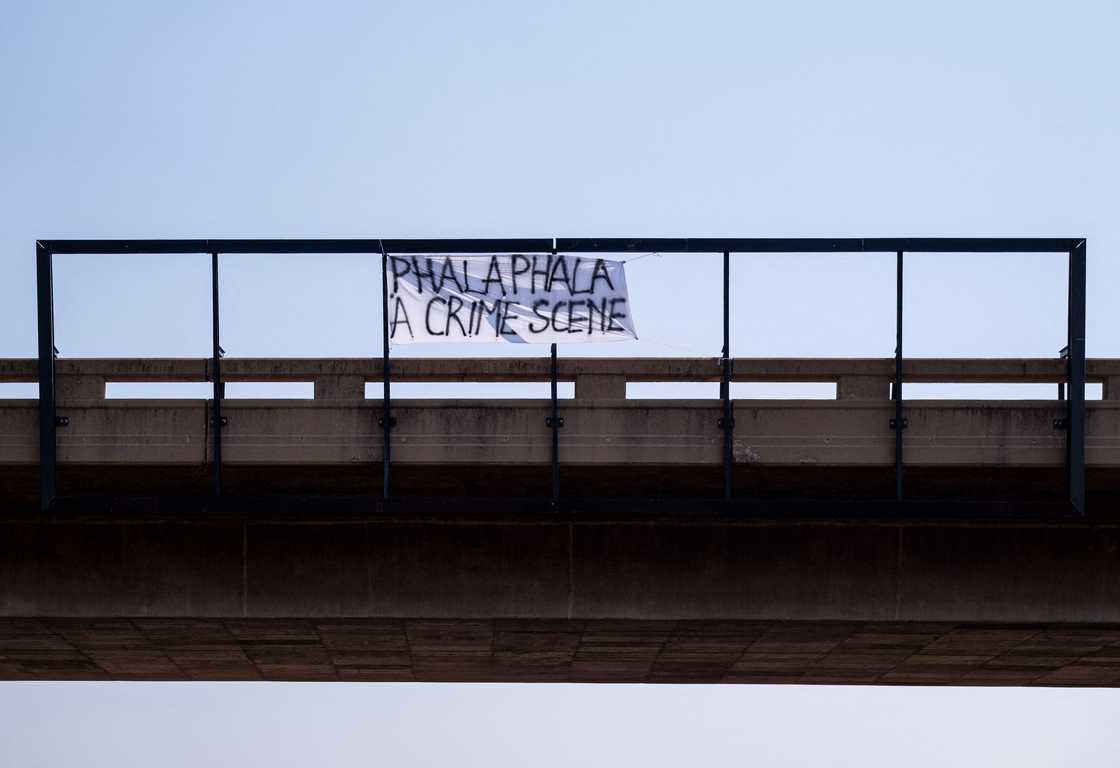 A handwritten sign on a bridge in Pretoria reads: Phala Phala a Crime Scene on the day of a national shut down protests organised by the Economic Freedom Fighters (EFF) on the N14 highway in Pretoria on March 20, 2023