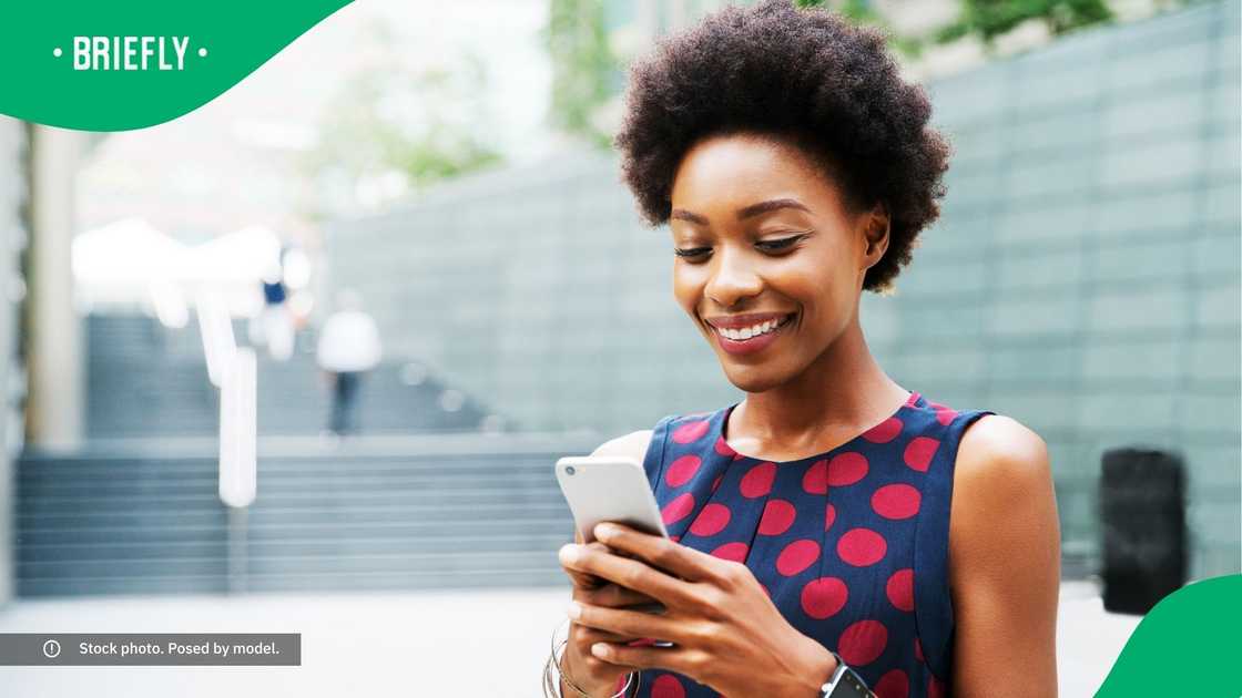 A woman smiling at her phone. A woman smiling at her phone.