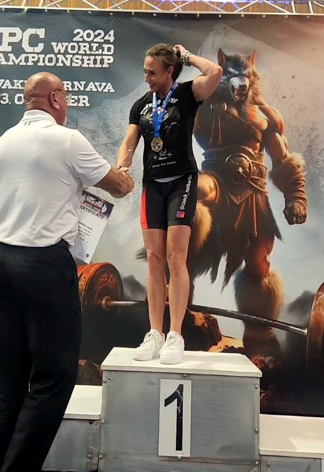 Nataly Barbosa celebrates on the platform after winning her division and setting world records at the World Powerlifting Championships.