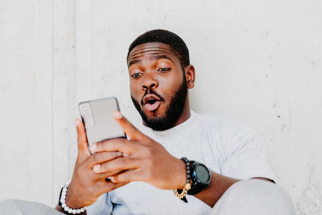 A man looking surprised at his phone.