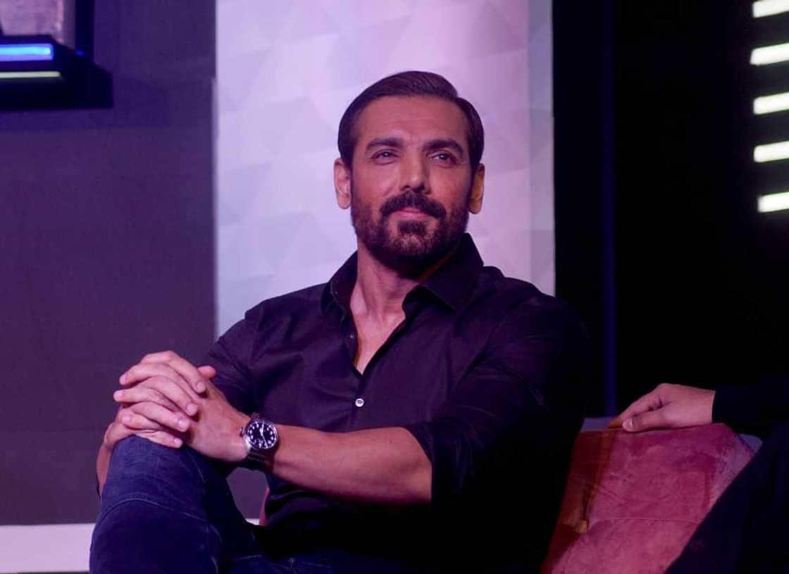 John Abraham posed on a chair and looked on John Abraham posed on a chair and looked on