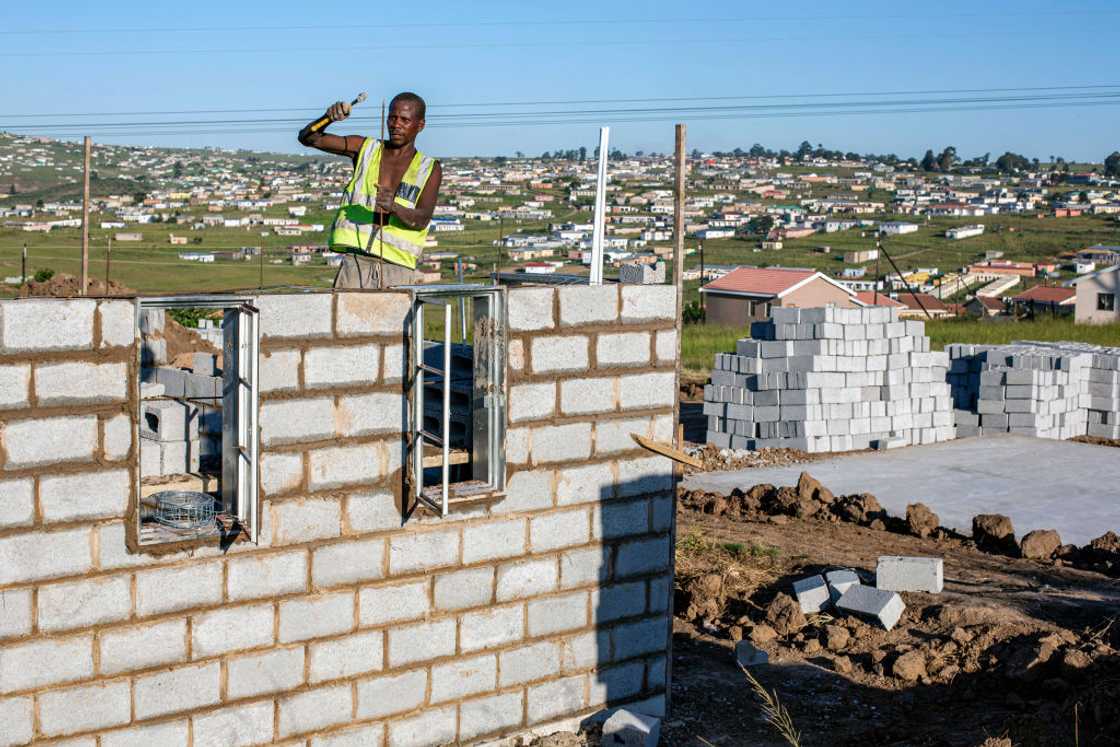 A picture of South African man building a RDP house A picture of South African man building a RDP house
