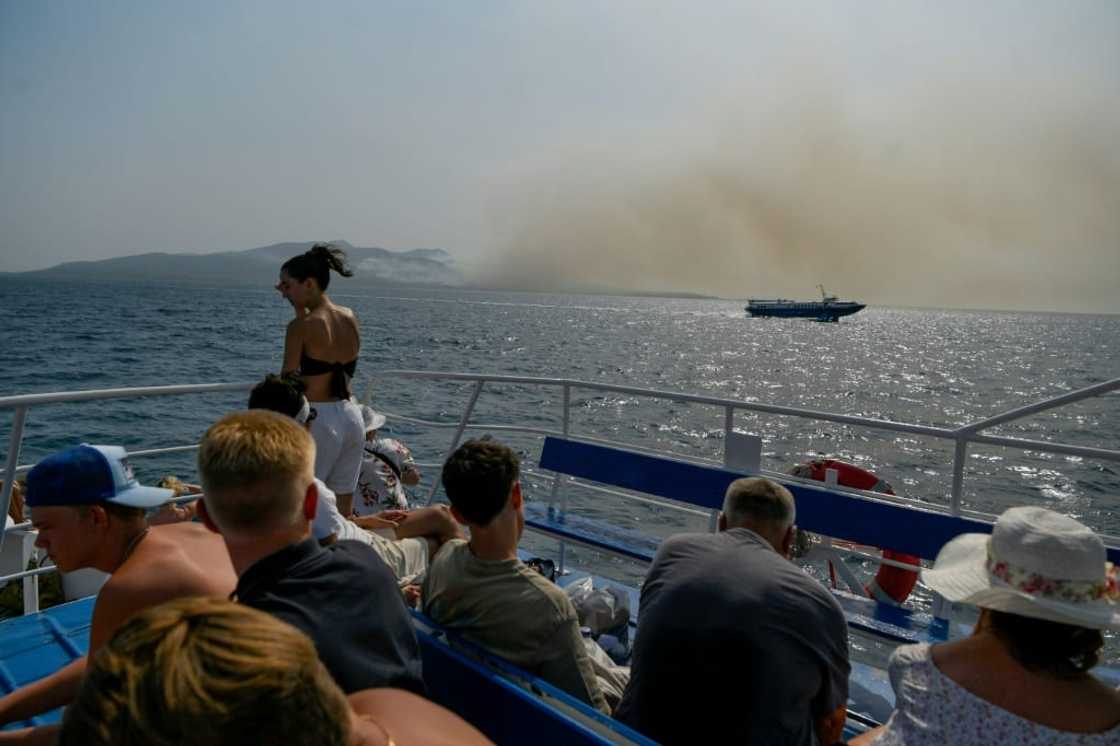 Smoke from fires were part of the scenery for tourists on a ferry to Greece's Corfu island Smoke from fires were part of the scenery for tourists on a ferry to Greece's Corfu island