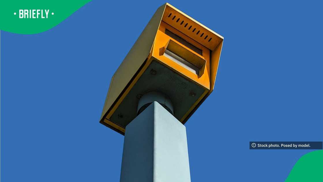 The low-angle photograph highlighted a bright yellow roadside safety camera used by traffic authorities to deter speeding