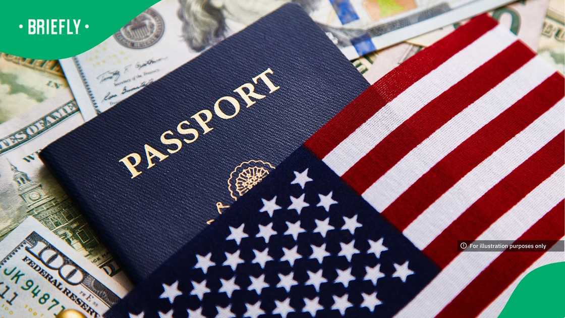 Conceptual still life of a passport and flag resting on a pile of fifty and one hundred dollar bills.