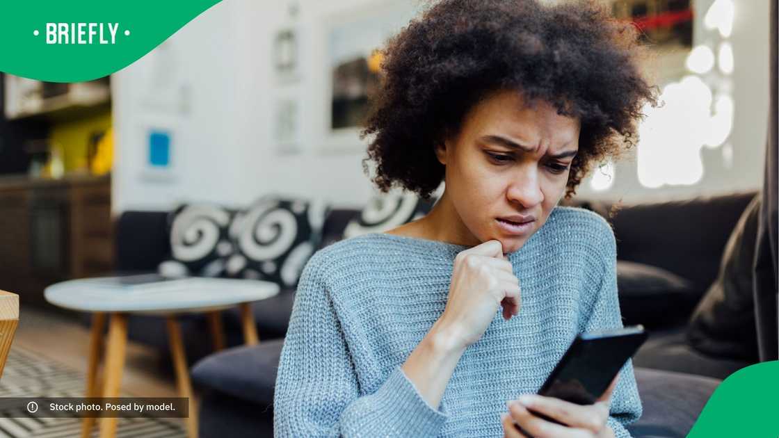 A sceptical woman looking at her phone.