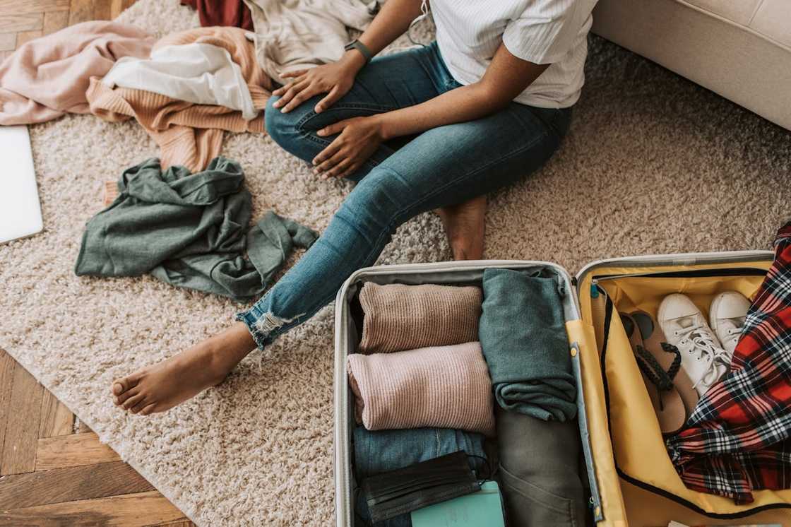 A woman packs her suitcase at home. A woman packs her suitcase at home.