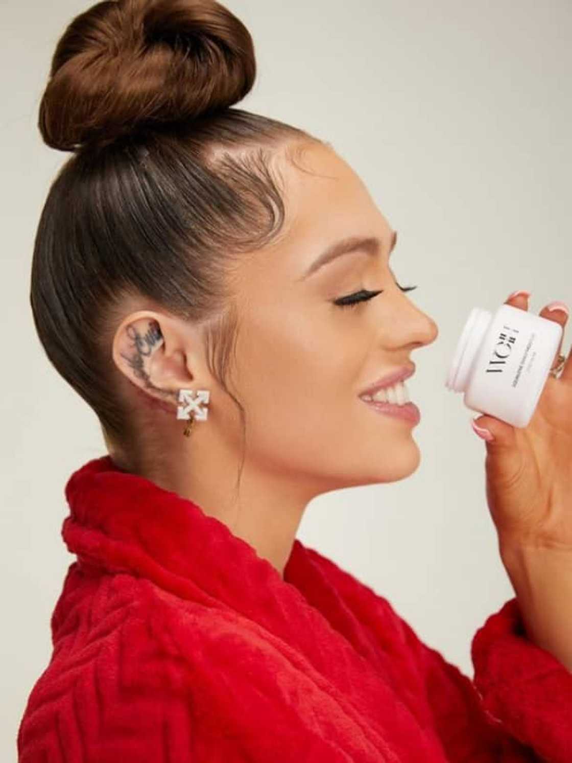 Woah Vicky with one of her skincare products from her range called WoahSkin.
