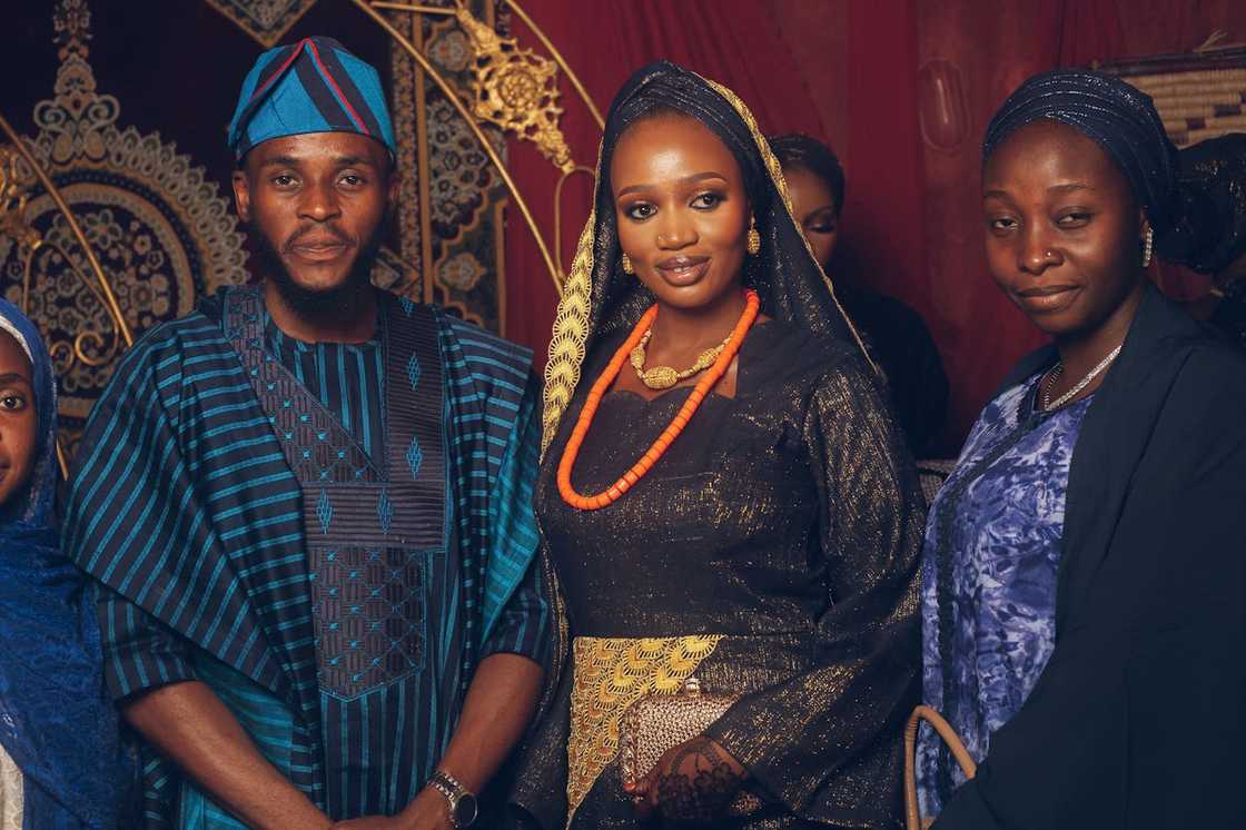 Group of people dressed in traditional attire posing together indoors.