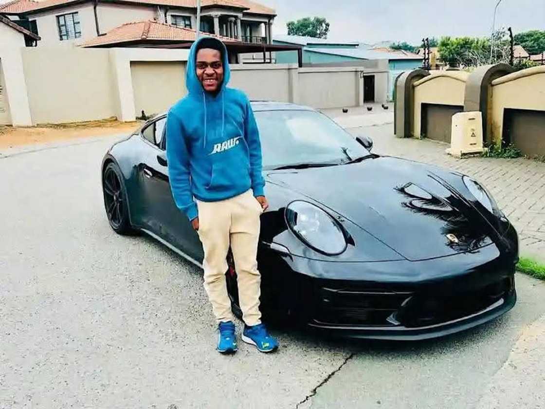 Mfundo Vilakazi strikes a confident pose beside a sleek Porsche. Mfundo Vilakazi strikes a confident pose beside a sleek Porsche.